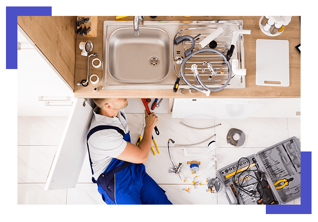 Male Plumber In Overall Fixing Sink Pipe